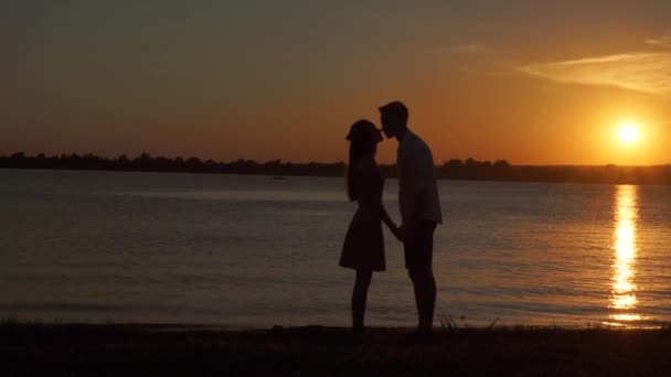 Milující starší pár, kteří požívají romantický západ slunce večer tančí spolu na pláži, natočeno - Záběry, video