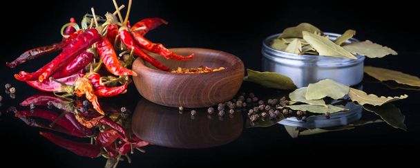 Épices et herbes, feuille de laurier, poivre noir et bol en bois de flocons de piment
 - Photo, image