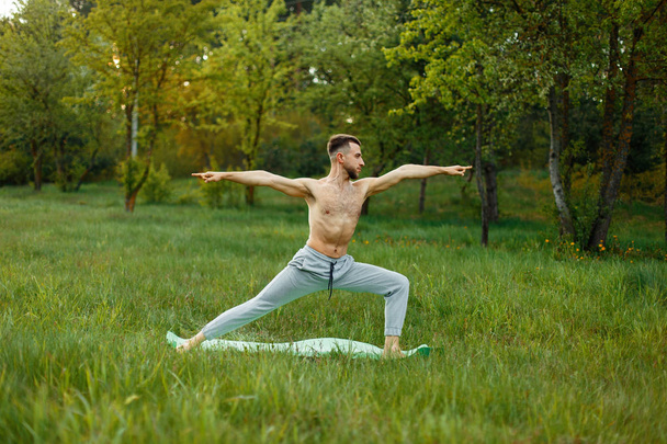 Homme pratiquant le yoga dans le jardin sur l'herbe
 - Photo, image