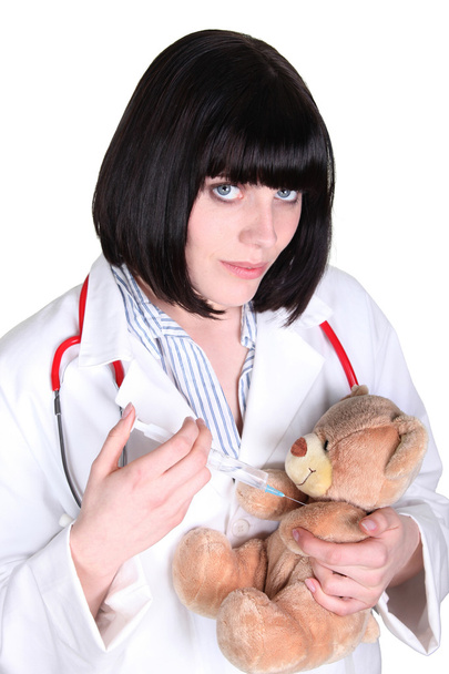 Жінка-лікар вводить плюшевого ведмедя
 - Фото, зображення