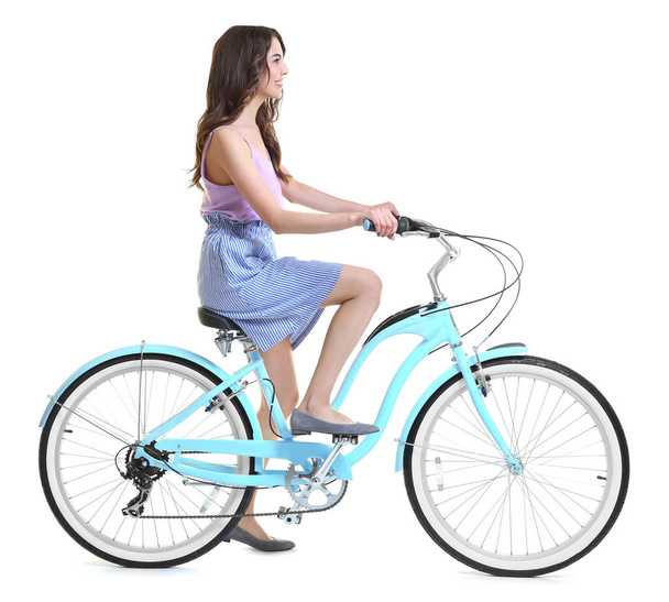 Beautiful young woman riding bicycle  - Фото, изображение