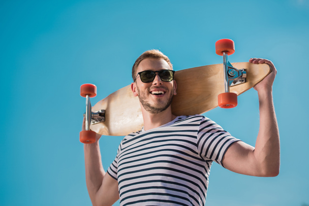 handsome man with skateboard - Фото, зображення