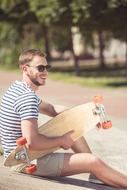 Красивий чоловік зі скейтбордом
 - Фото, зображення