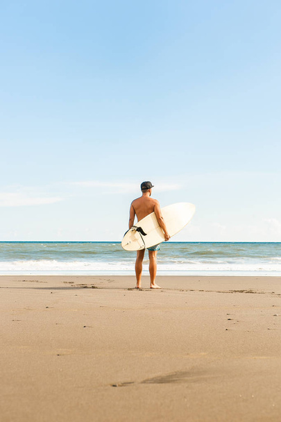 Handsome man with surfing board on spot. - Foto, afbeelding