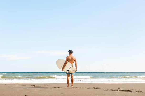 Handsome man with surfing board on spot. - Foto, imagen