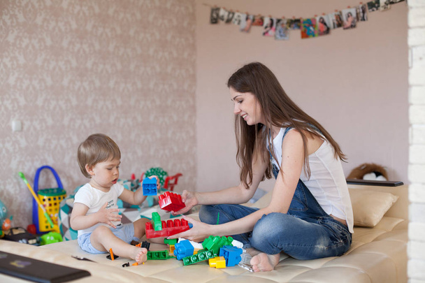 mother and little boy play with toys in the nursery - Фото, зображення