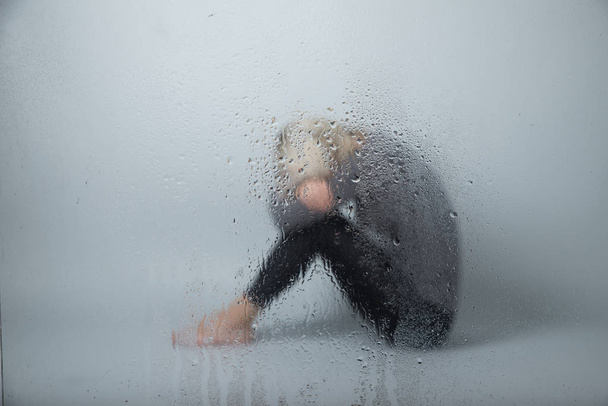 La mujer de la depresión se sienta en el suelo
 - Foto, Imagen
