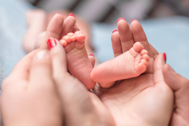 赤ん坊足で母親の手 - 写真・画像