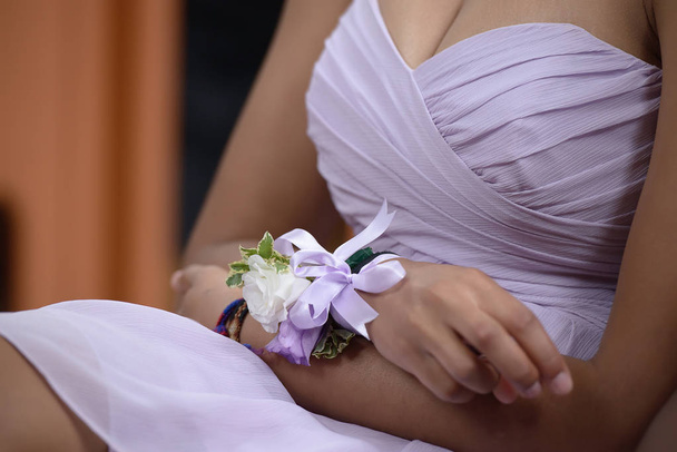 Close-up of young Caucasian woman, sitting down at a wedding ceremony and holding fingers into a nervous gesture. - Photo, Image