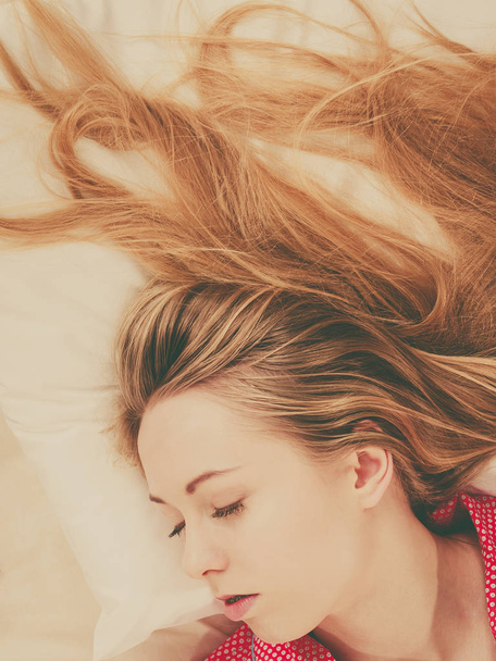 Молодая женщина лежит на кровати в пижаме
 - Фото, изображение