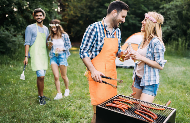 Beautiful woman and handsome man having barbecue - 写真・画像
