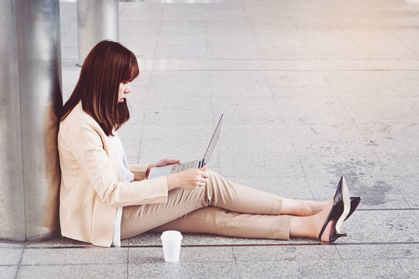 Businesswoman in high heels sitting on floor with computer in he - Photo, Image