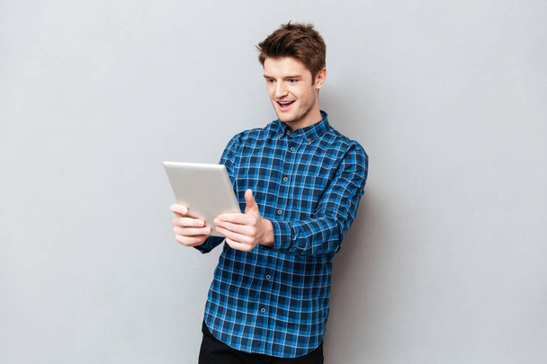 Surprised man looking at tablet computer isolated - Photo, Image