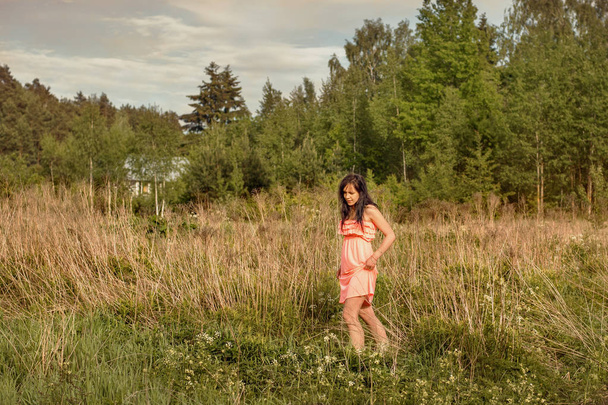 Young girl goes sneaking through tall grass to a swamp field - Fotografie, Obrázek