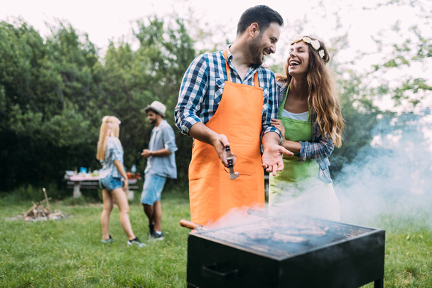 Beautiful woman and handsome man having barbecue - Foto, afbeelding