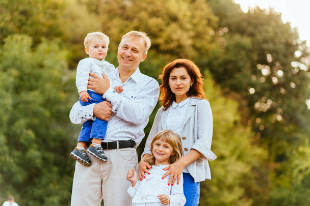 glückliche Familie mit Vater, Mutter und zwei Kindern, Sohn und Tochter im Sommerpark. - Foto, Bild
