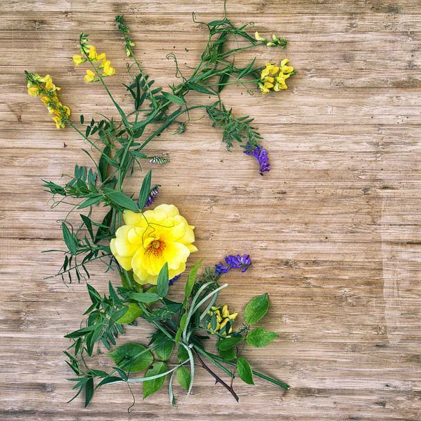 плоская укладка желтой розы и диких цветов на деревянном столе с копировальным пространством для текста
 - Фото, изображение