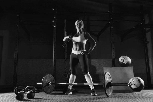 Young fitness girl is standing in the gym - Фото, изображение