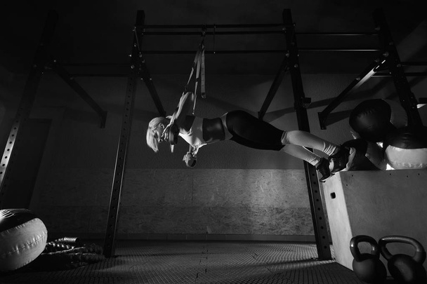 Fitness woman workout on the TRX in the gym - Zdjęcie, obraz