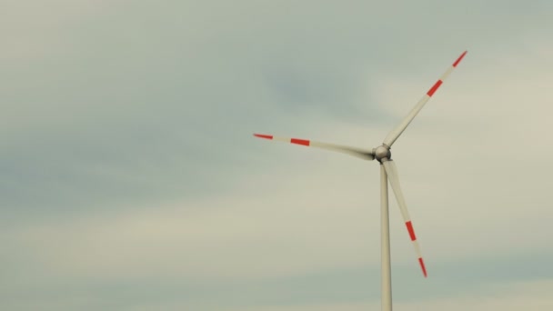 Regelmatige windturbines draaien in de wind op een blauwe hemel. - Video