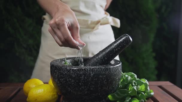 Housewife adds salt to the grinder with natural sauce, cooking food, spicy food, vegetarian meal, greens and salads, cooking outdoors - Footage, Video