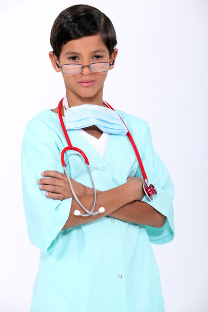 Niño vestido como un médico presumido en matorrales
 - Foto, imagen