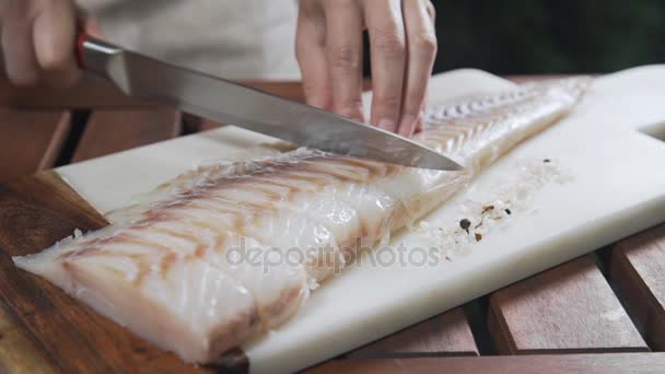 Chef está rebanando bacalao crudo en el tablero antes de asarlo, cocinar al aire libre, parrilla de pescado y barbacoa
 - Metraje, vídeo