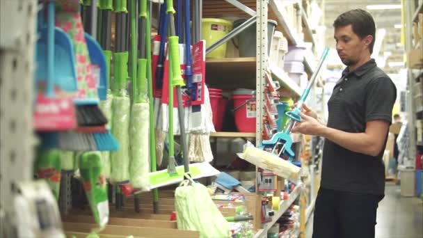 Homme client chef de ménage en choisissant une serpillière dans le supermarché
 - Séquence, vidéo