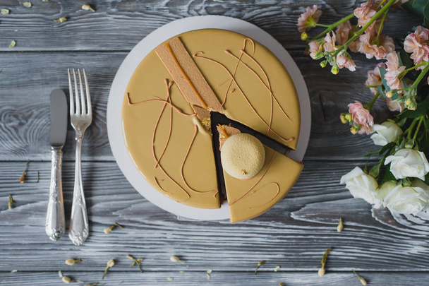 珍しい黄色のムース ケーキ アーモンドのダクワーズ、ラズベリーのコンフィ、ヘーゼル ナッツとラズベリー パウダー、木製にビター チョコレートのムースとサクサクの層の部分でパン屋さん - 写真・画像