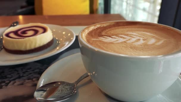 Detailní záběr na šálek kávy s latte art - Záběry, video