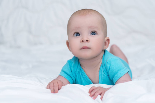 Adorable baby girl or boy in blue shirt with big blue eyes, indo - Zdjęcie, obraz