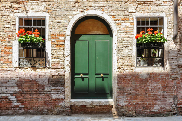 Puertas cerradas en una casa de ladrillo tradicional muy antigua en Venecia, Italia
 - Foto, Imagen