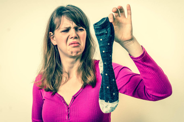 Femme tenant sale chaussettes puantes - style rétro
 - Photo, image