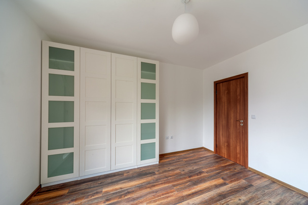 Современный дом, пустая комната с белым шкафом, деревянный пол
 - Фото, изображение