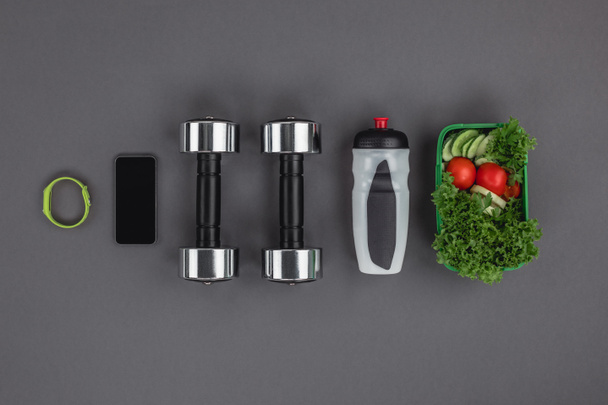 Dumbbells with vegetable salad and gadgets - Photo, Image