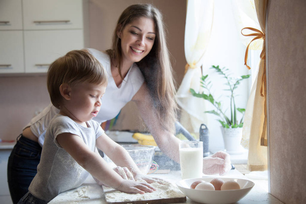 mother and young son prepare a cake in the kitchen - Photo, Image