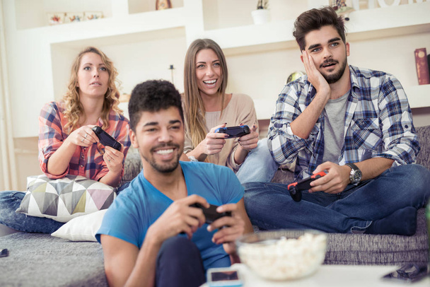 τους φίλους παίζοντας βιντεοπαιχνίδια στο σπίτι - Φωτογραφία, εικόνα