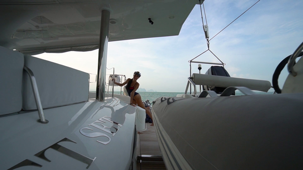 Dívka pózuje v kapitáni čepici na zádi jachty. Výhled na moře. - Záběry, video