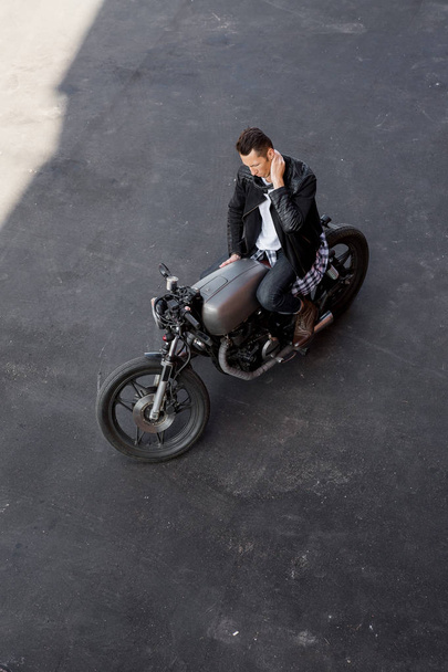 Top view to brutal man with cafe racer custom motorbike. - Foto, immagini