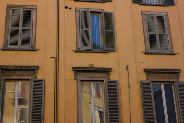 Muchas ventanas. Fachada medieval. Persianas de ventana. Estilo arquitectónico de Italia
 - Foto, imagen