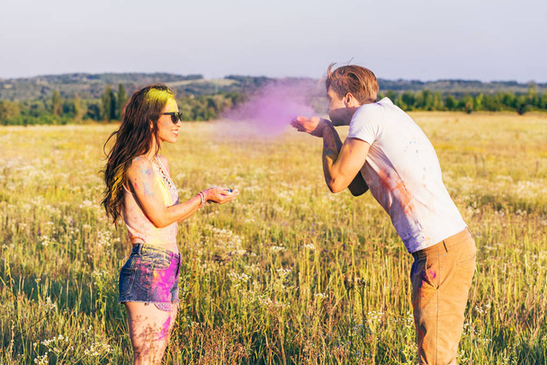 couple having fun during holi festival in field - Photo, Image