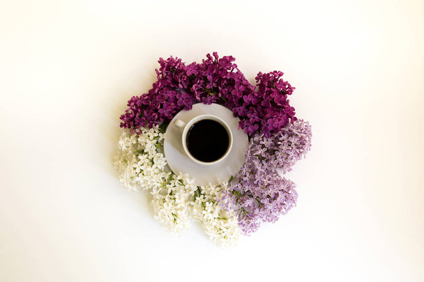 Top view of the cup with lilac on white background.  - 写真・画像