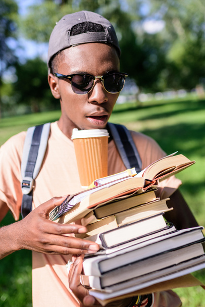 young man with pile of books - Foto, afbeelding