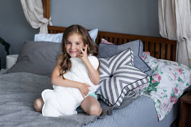 Malá holčička hraje na posteli v ložnici - Fotografie, Obrázek