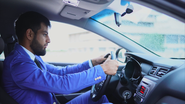 Hombre musulmán sentado en el asiento del conductor en el coche y escribiendo en el teléfono inteligente
 - Imágenes, Vídeo