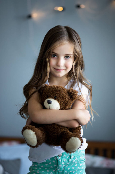 Portrait of a beautiful girl with a brown toy bear - Фото, зображення