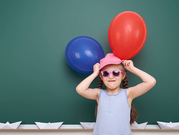 Школа девушка с бумажной лодкой и воздушным шаром играть рядом с доской, пустое пространство, концепция образования
 - Фото, изображение