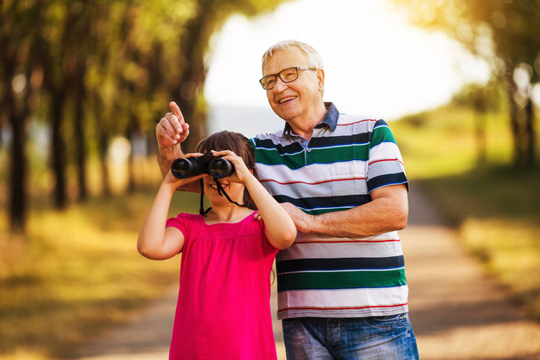 Grandfather and granddaughter spending time in nature - 写真・画像