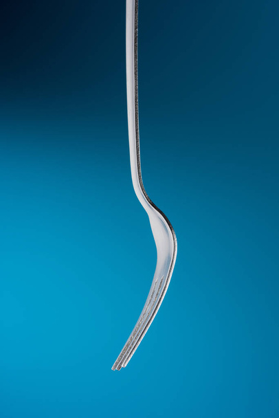 Fork in blue background - Fotoğraf, Görsel
