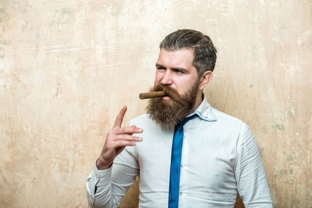 man on serious face smoking cigar - Фото, изображение